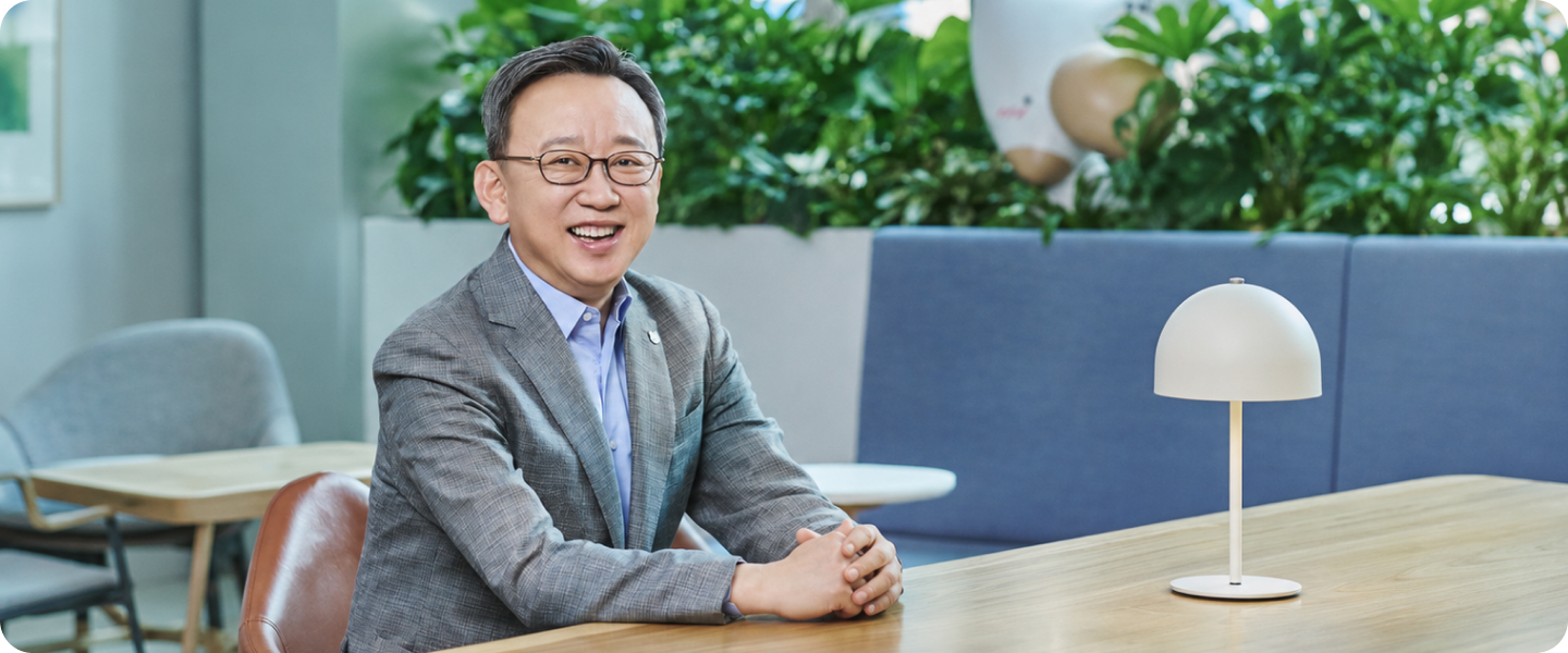 회의실 테이블에 앉아 미소 짓고 있는 신한미소금융재단 이사장 정상혁